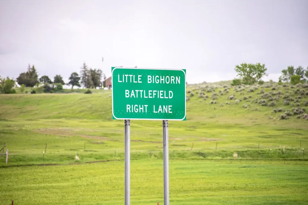 A road sign for Little Bighorn Battlefield, indicating the right lane.