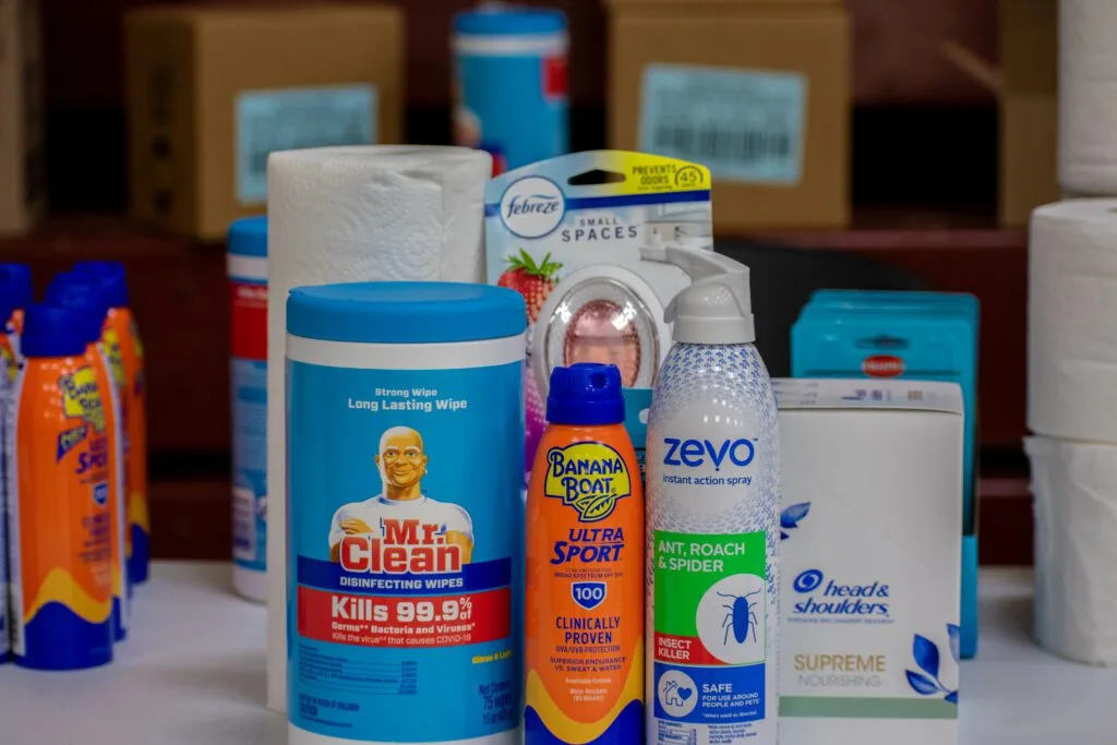 Various cleaning and personal care products, including wipes, bug spray, and sunscreen, are displayed.