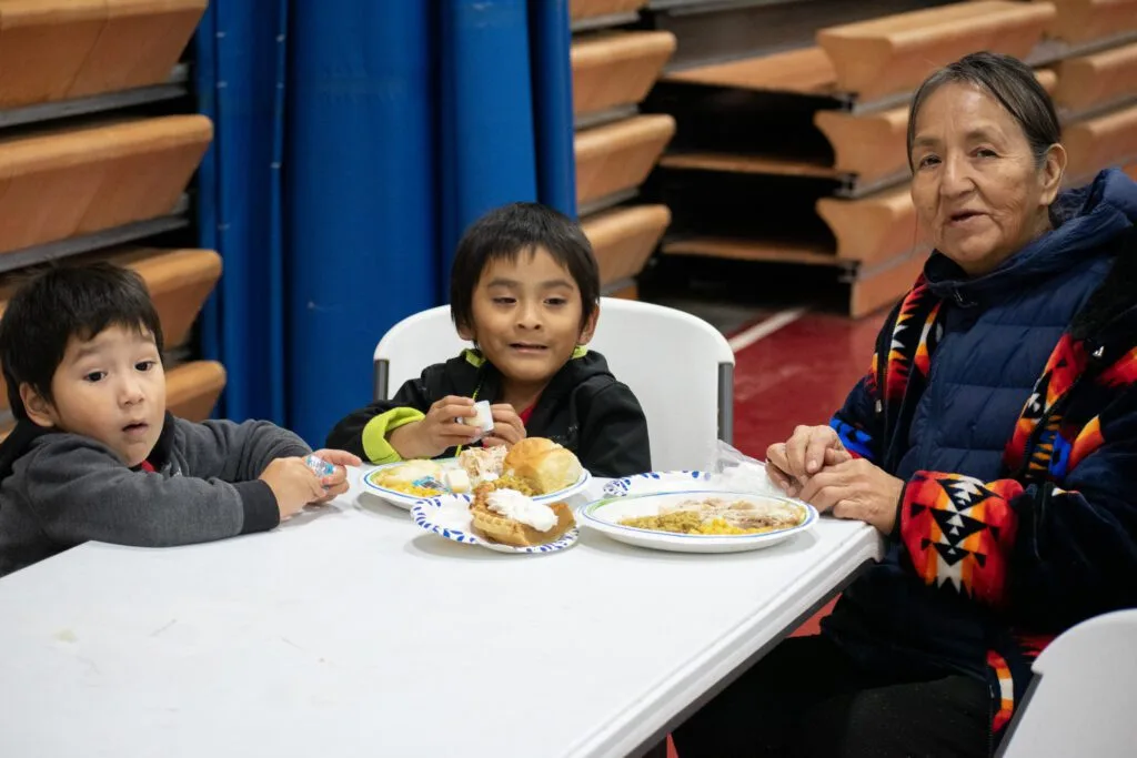 A family sitting at a table, enjoying a meal together.