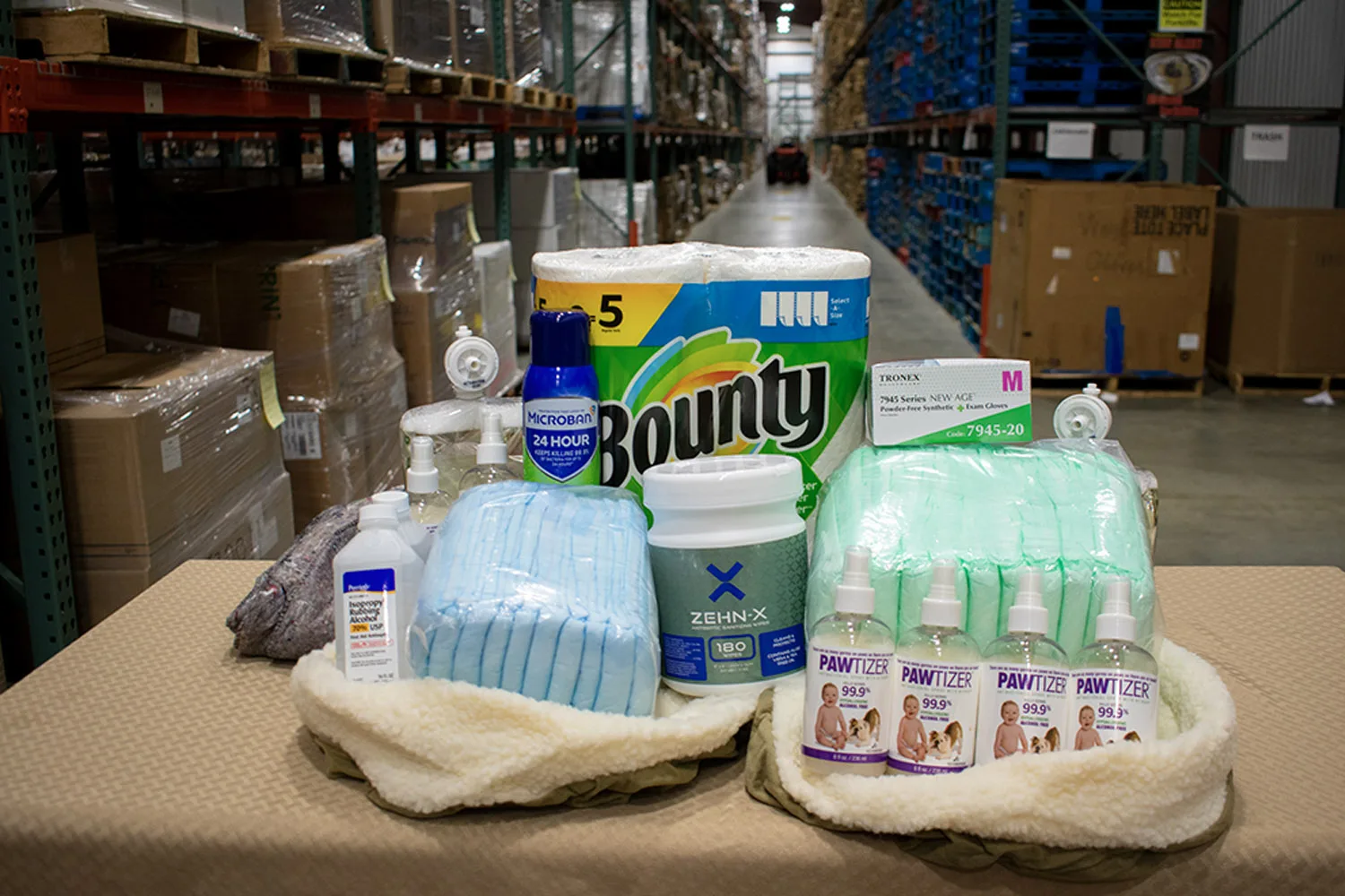 Various cleaning and hygiene supplies, including Bounty paper towels, disinfectants, gloves, and sanitizers are displayed.