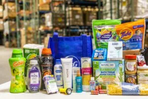 A collection of household products, including cleaning supplies, personal care items, and groceries, is displayed on a table.